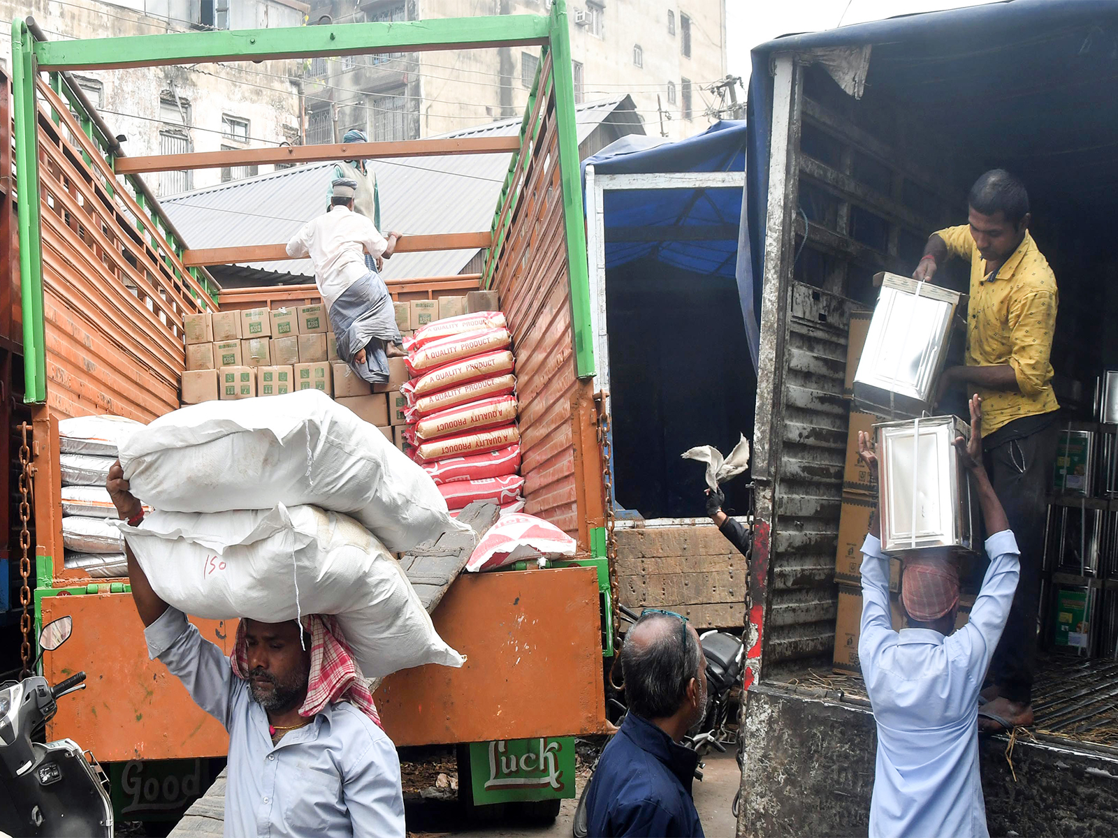 Labourers load food items on a truck in a wholesale market (Photo/ANI)