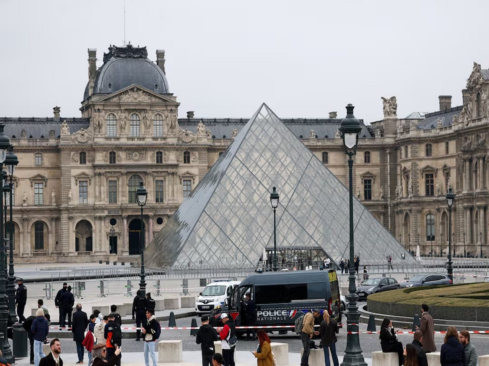 Police stand near the Louvre Museum pyramid following a robbery (Photo/Reuters)