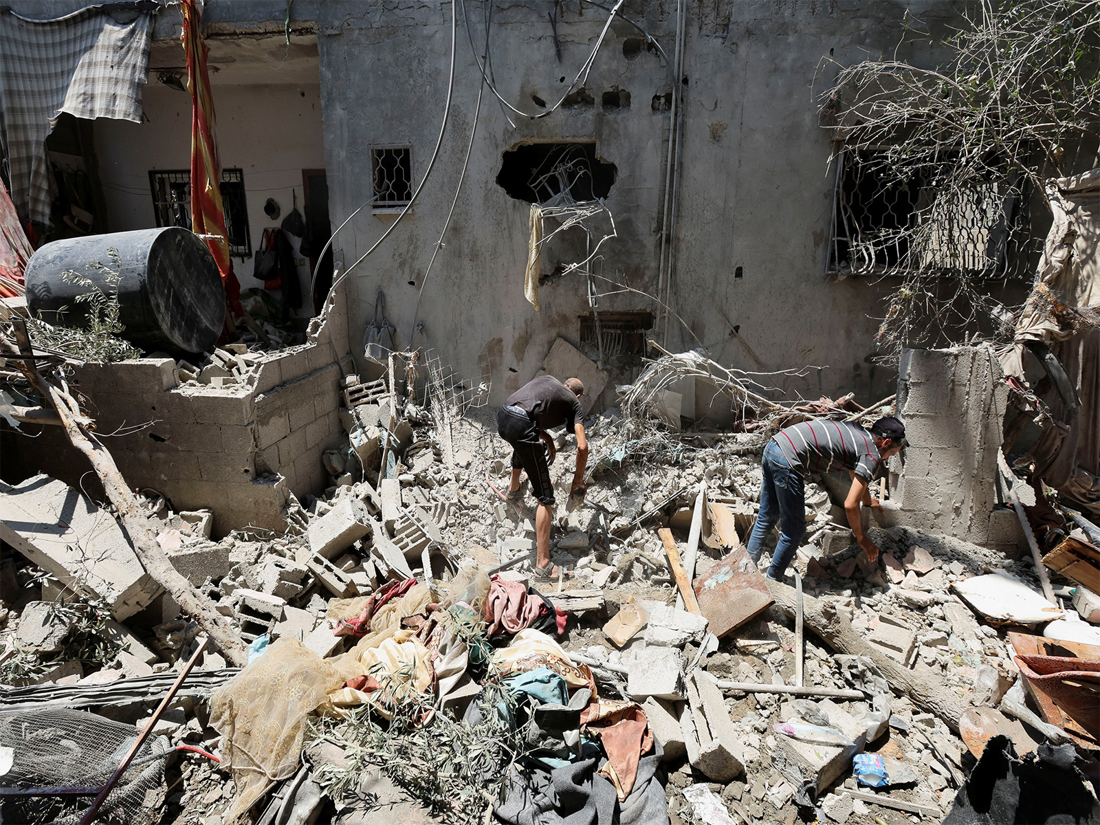 Palestinians inspect a house damaged in Israeli air strike. (File Photo/Reuters)