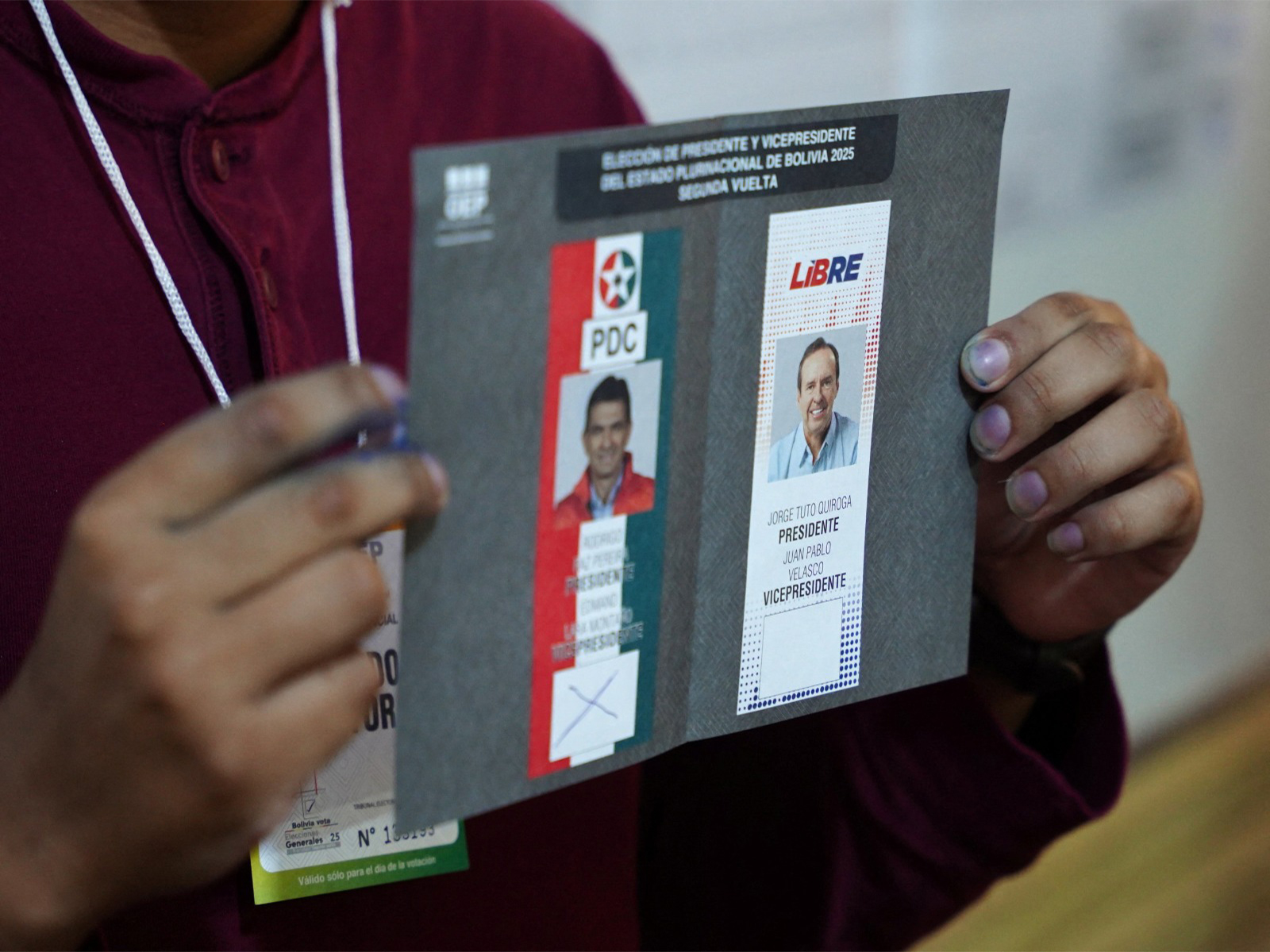 A person shows a ballot as electoral workers count votes on the day of the presidential runoff election in Tarija, Bolivia (Photo/Reuters)