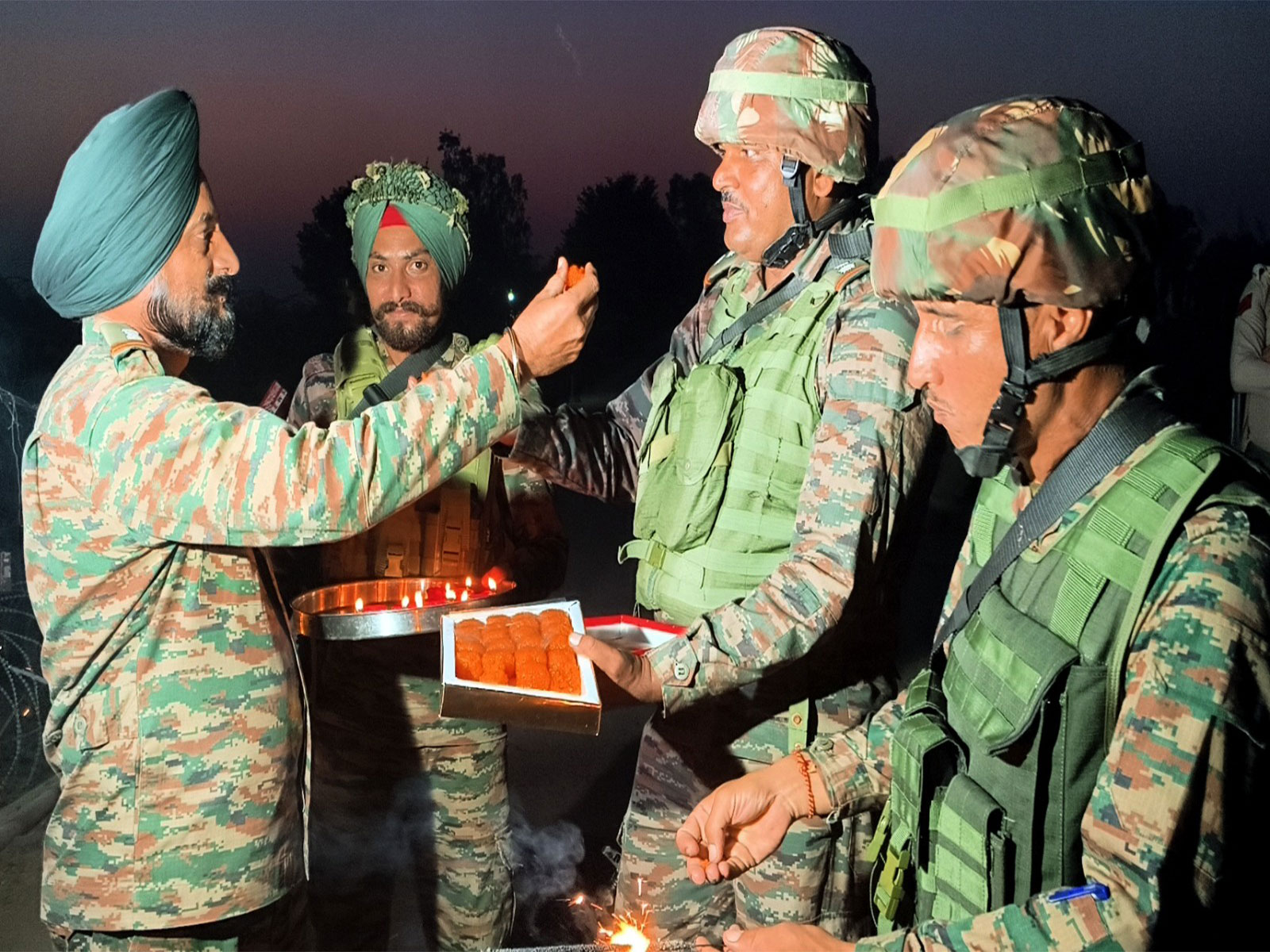 Army soldiers offer sweets as they celebrate Diwali festival at LoC at Akhnoor sector. (Photo/ANI)
