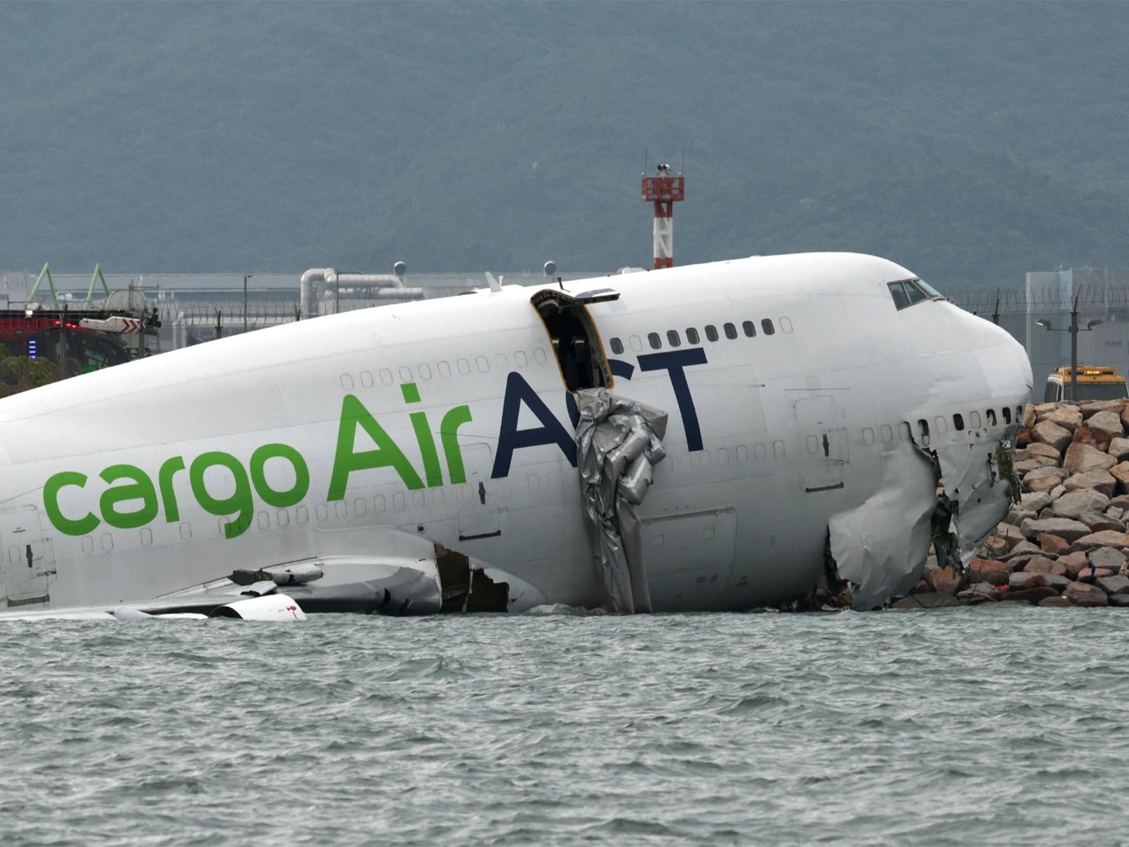 A cargo plane lies partially in the sea after veering off the runway during landing at Hong Kong International Airport on October 20, 2025. (Photo/Reuters)