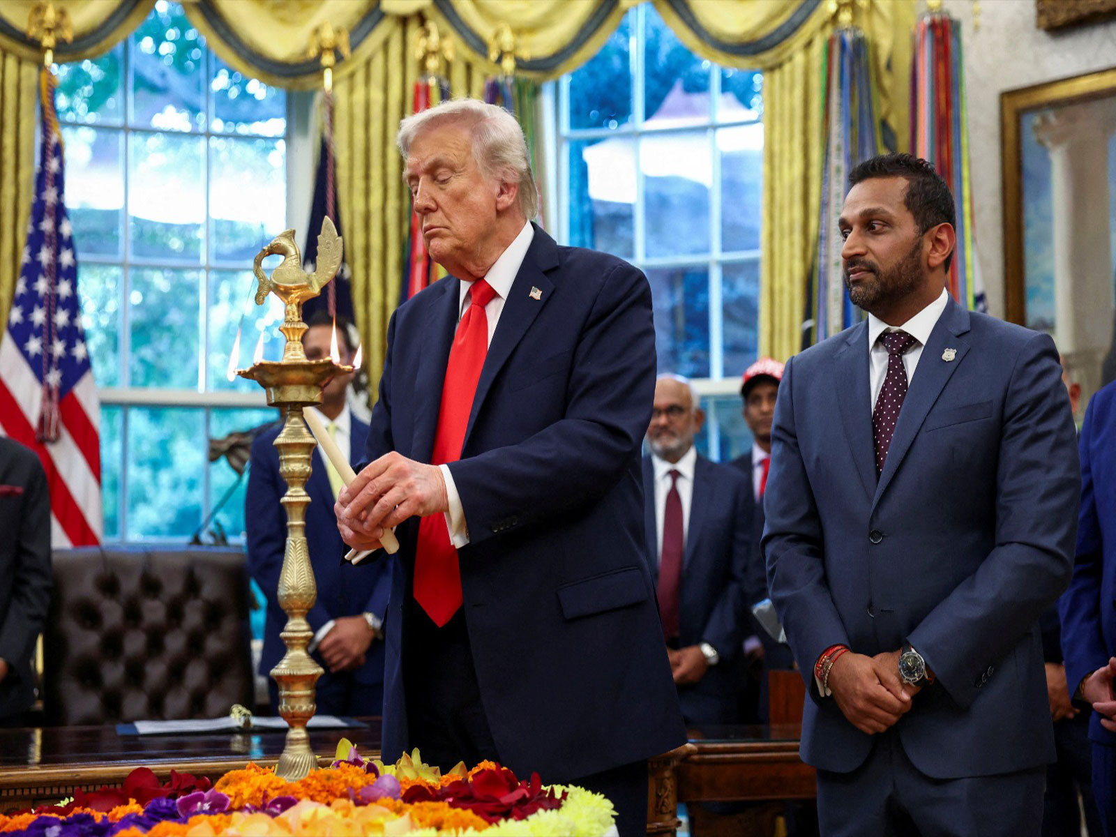 US President Donald Trump lights a candle as he participates in a Diwali celebration at the White House alongside FBI Director Kash Patel (Photo/Reuters)