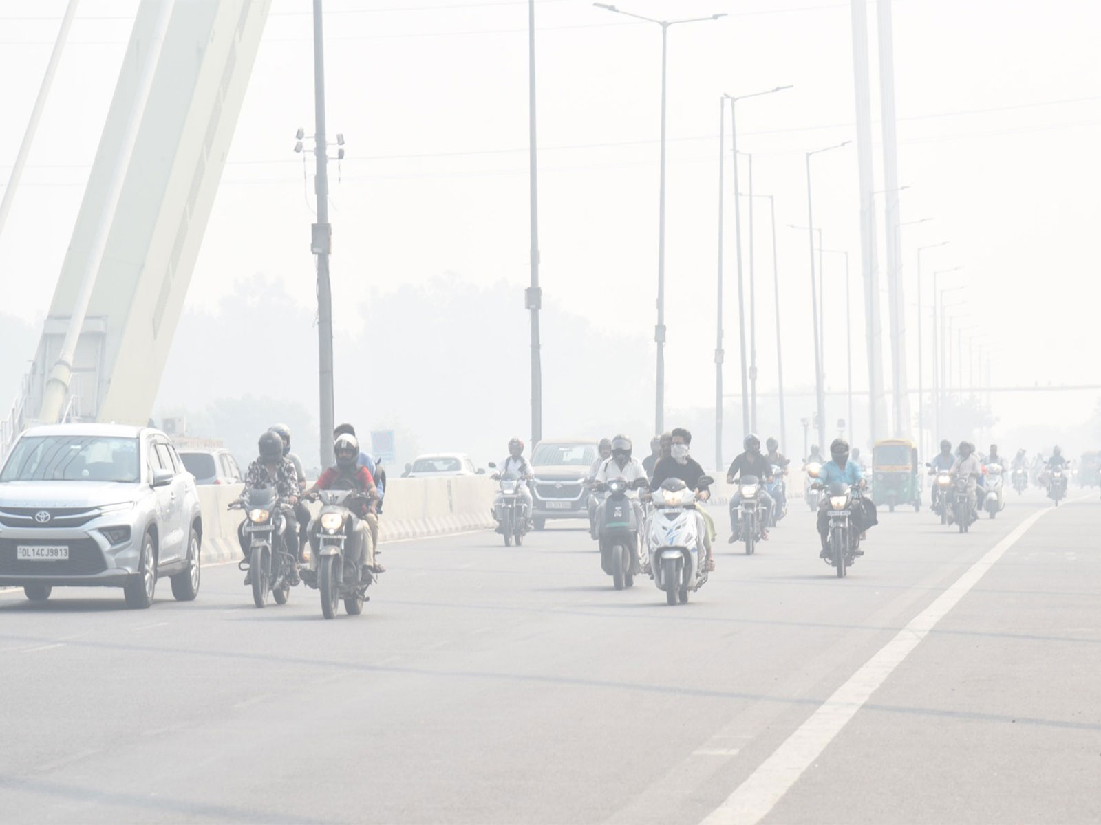 Commuters wading through a thin layer of smog at Signature Bridge in New Delhi (Photo/ANI)