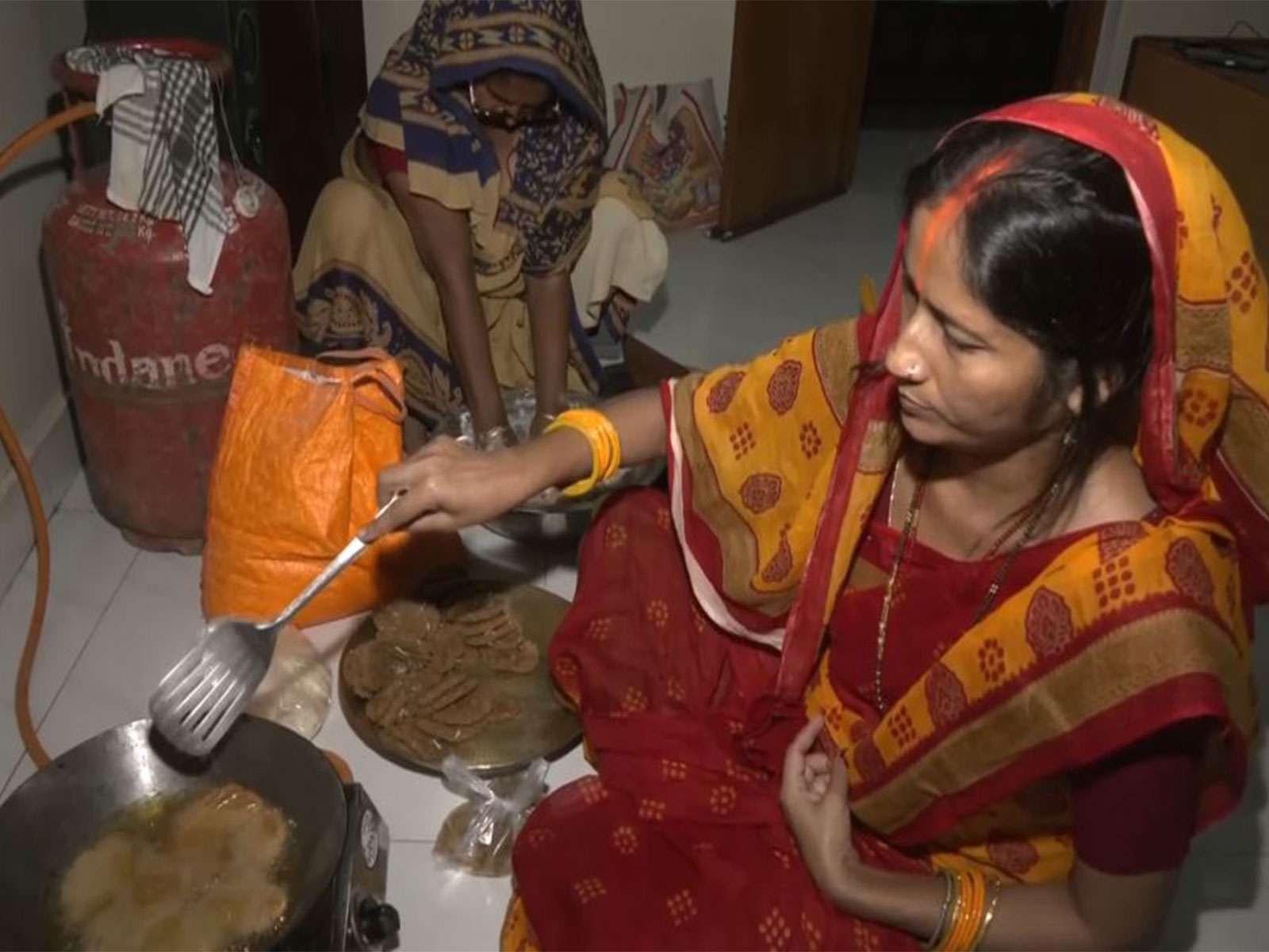 Woman preparing sweet dish 'Thekua' for 'arghya' to the setting Sun this evening (Photo/ANI)