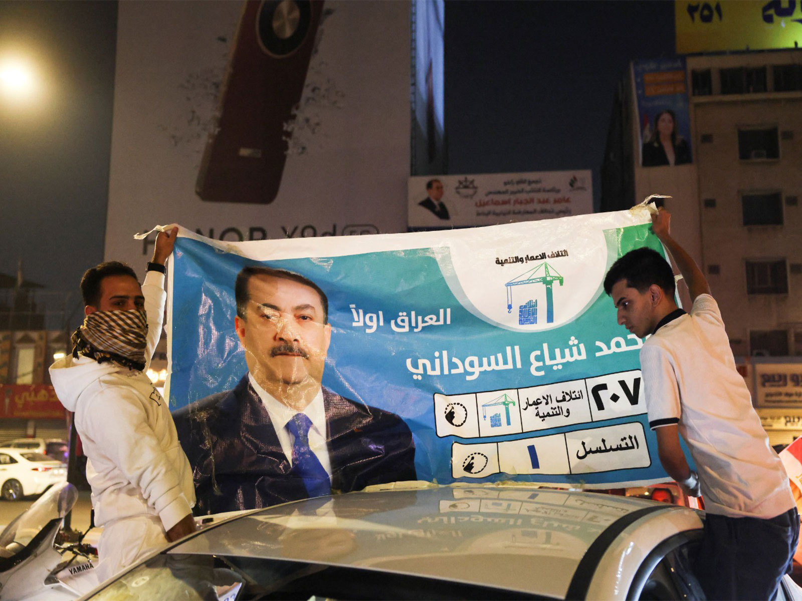 People hold an election poster featuring current Prime Minister Mohammed Shia' al-Sudani on top of a car (Photo/Reuters) People hold an election poster featuring current Prime Minister Mohammed Shia' al-Sudani on top of a car (Photo/Reuters)