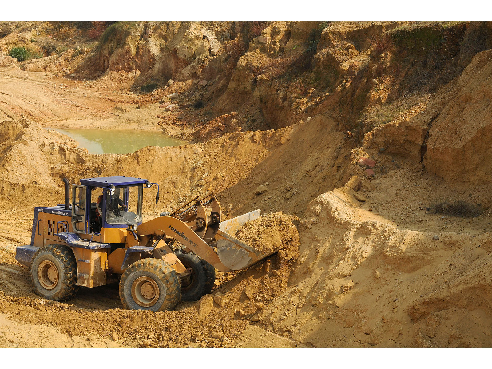 A worker drives a skip loader while working at the site of a rare earth metals mine at Nancheng county in China (Photo/Reuters)