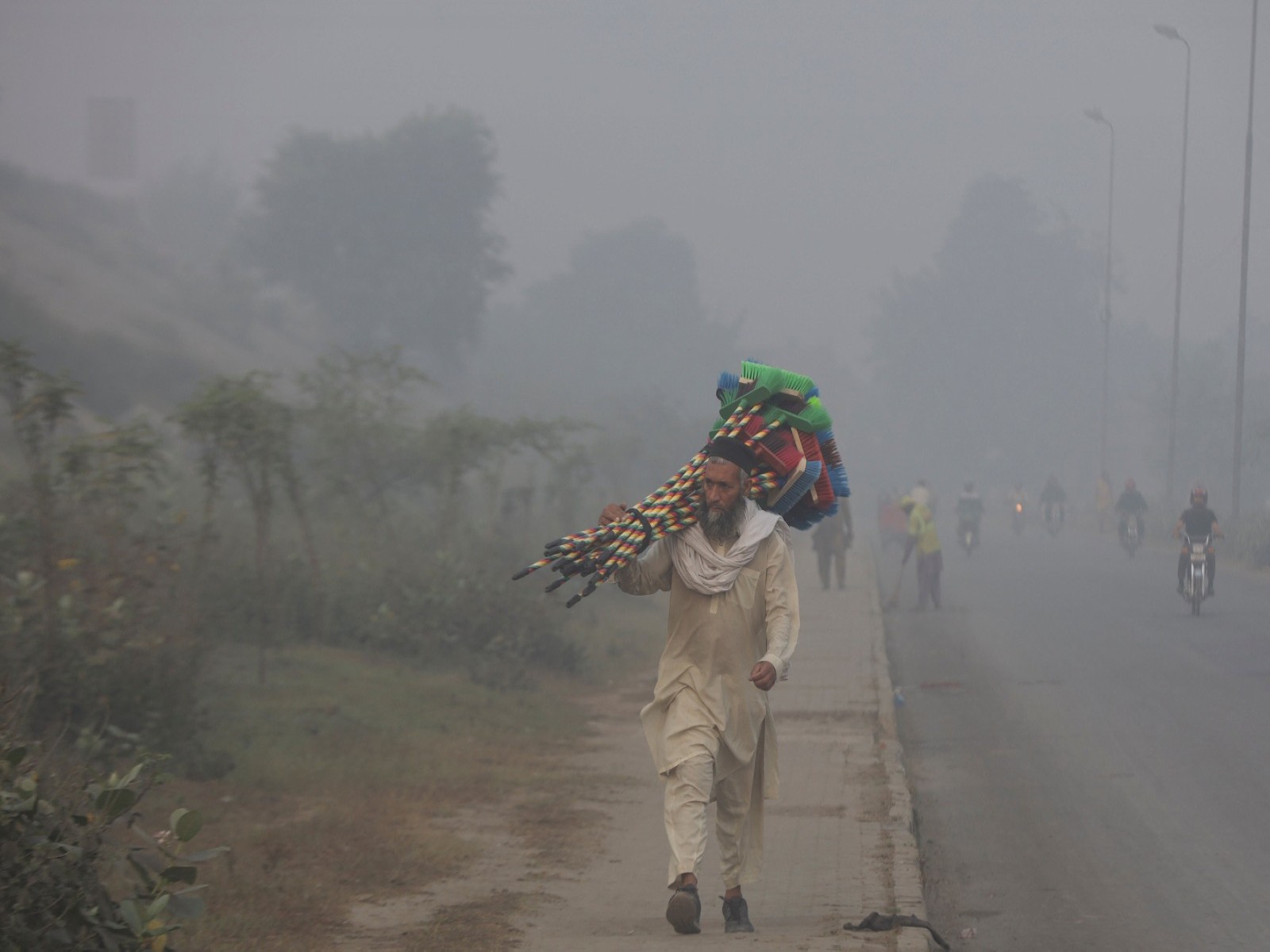 A man walks amid pollution and smoke in Lahore (Photo/ Reuters)