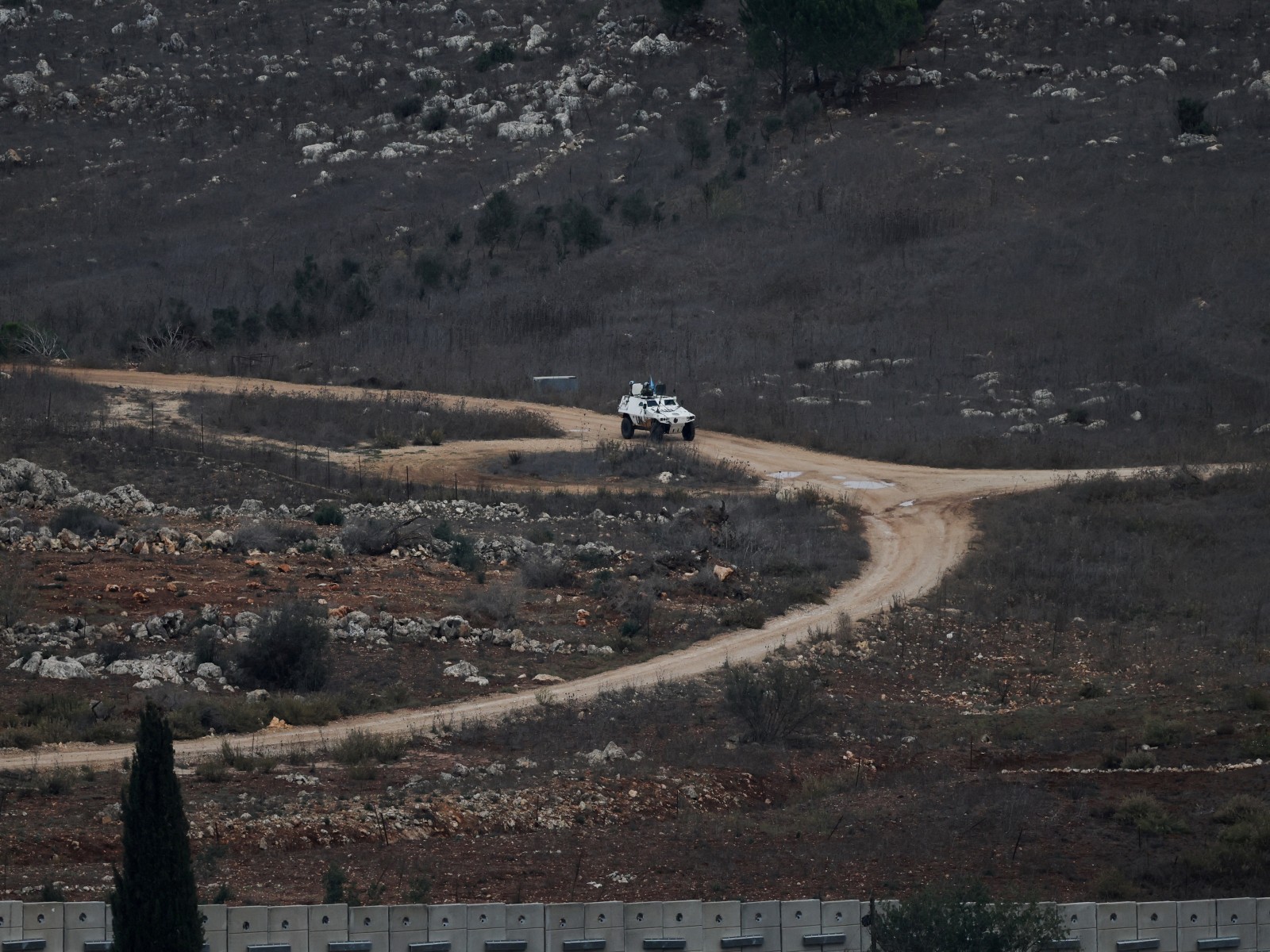 A UN vehicle drives near a concrete wall along Lebanon's southern border which, according to the Lebanese presidency, extends beyond the 