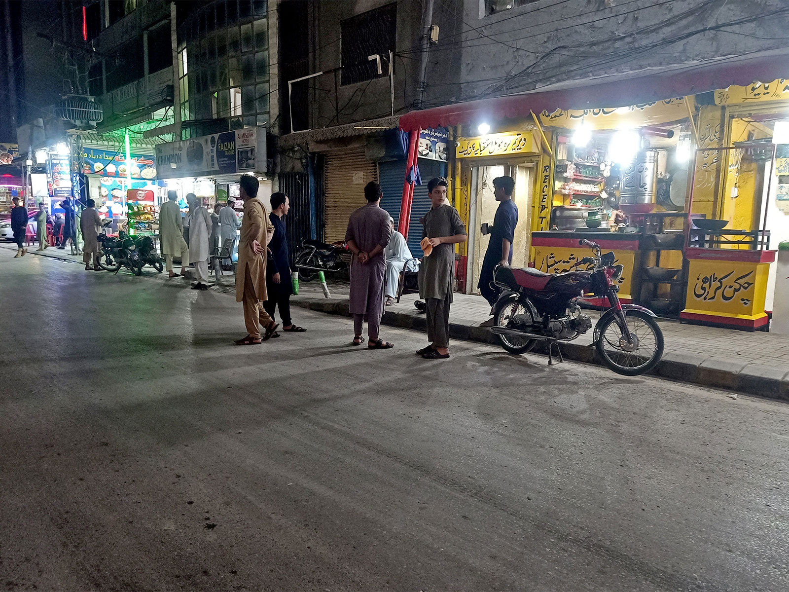 People stand in the street after they vacated eateries following an earthquake in Peshawar (File Photo/Reuters)