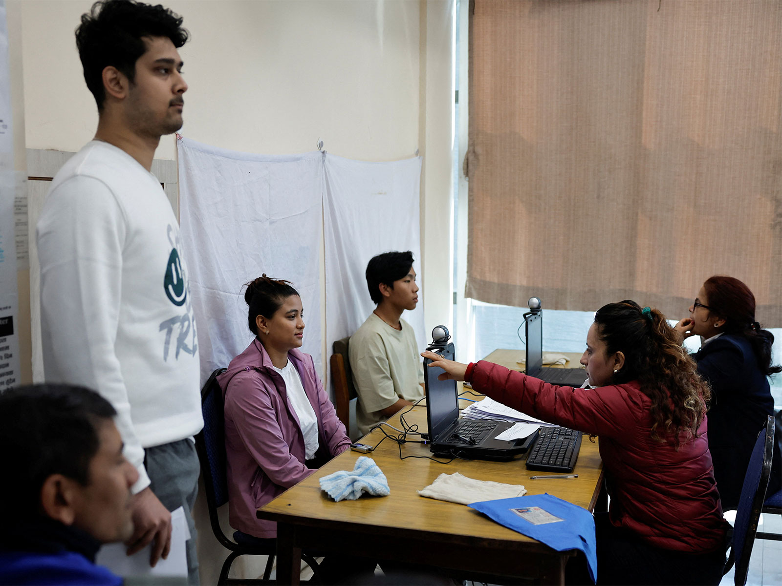 People give their biometric information to register on the voters' list for the upcoming House of Representatives elections (Phoro/Reuters)