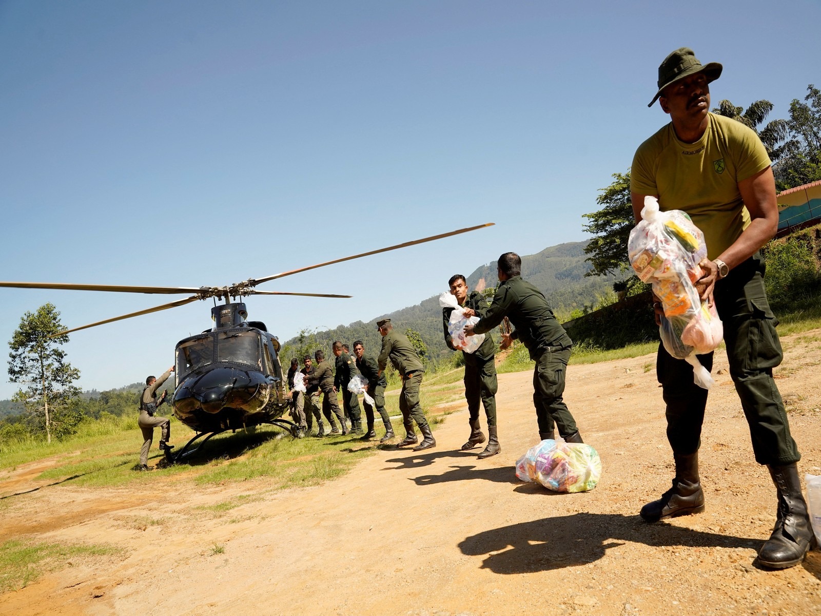 Sri Lanka Army soldiers unload relief material from a helicopter for flood victims following Cyclone Ditwah (Photo/ Reuters) 