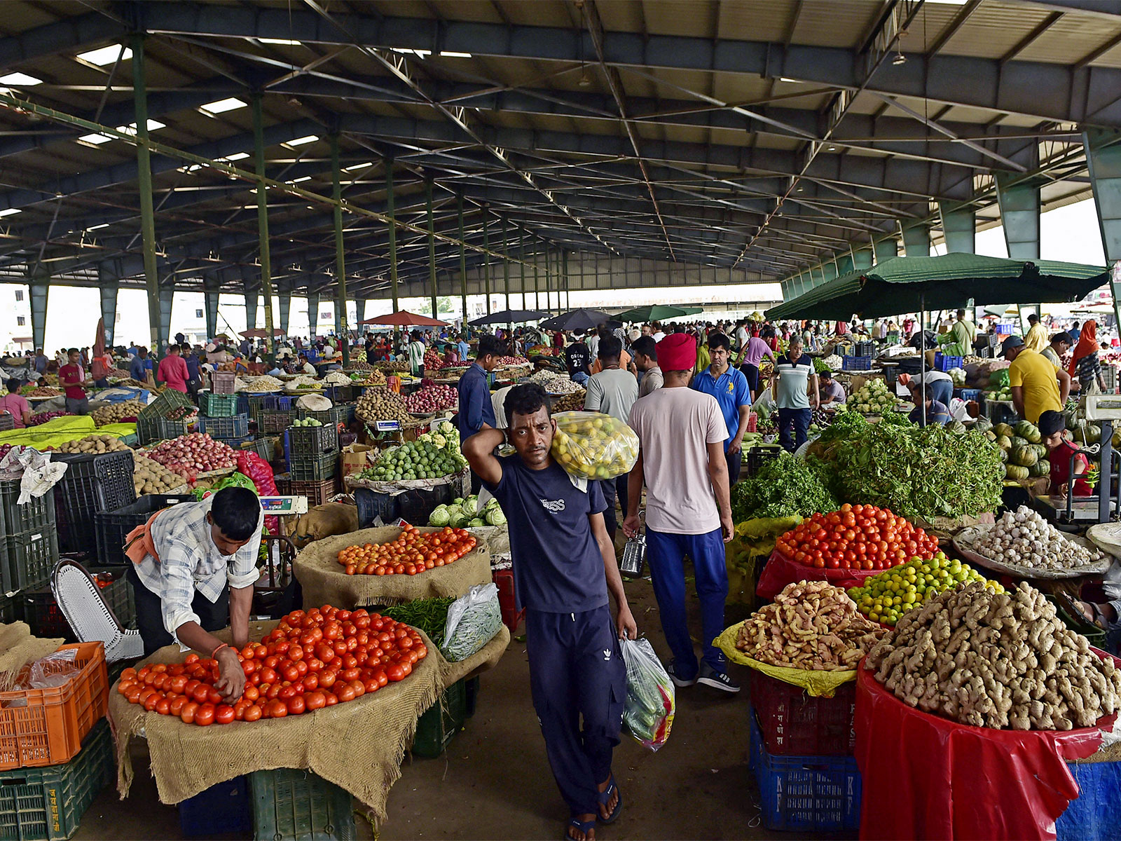 People buying vegetables at a wholesale market (File Photo/ANI)