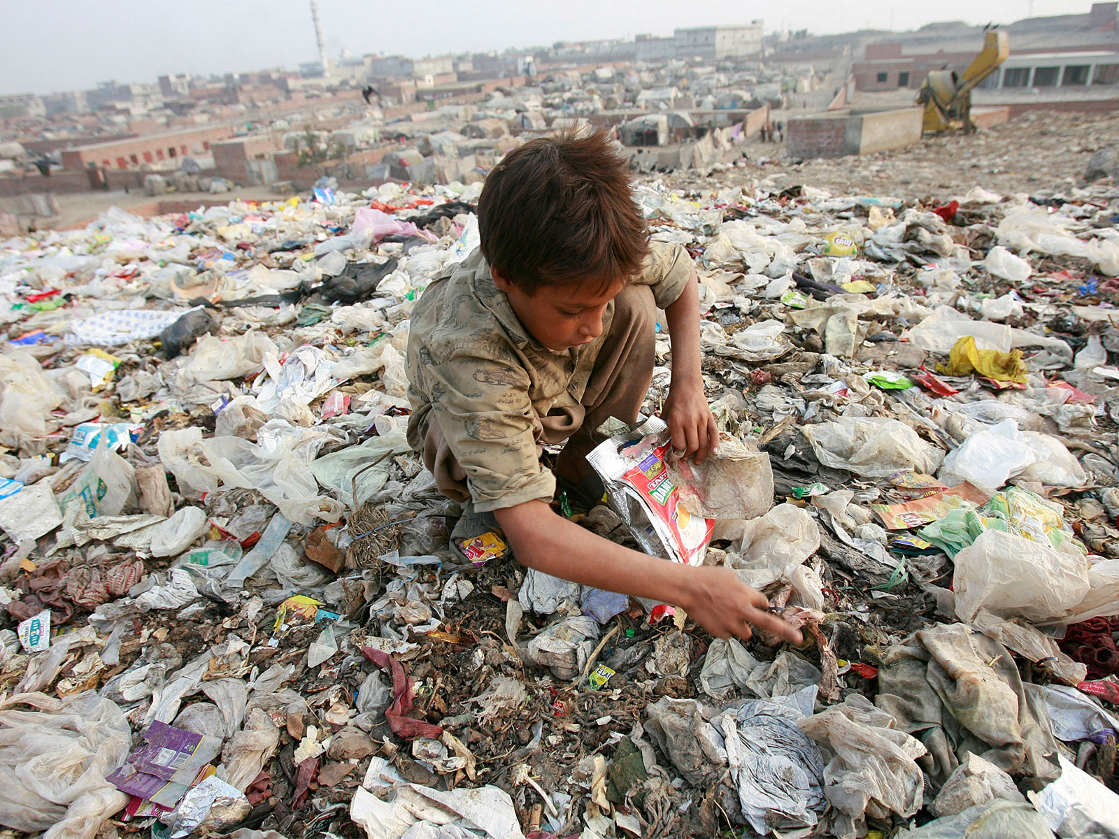 A boy scavenges through a garbage dump at a slum (Photo/Reuters)