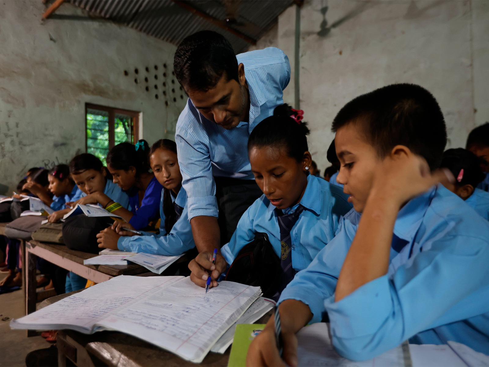 A teacher assists students during a class at a government school in Nepal, highlighting everyday classroom learning amid broader reforms in the country’s education assessment system. (Photo/Reuters)