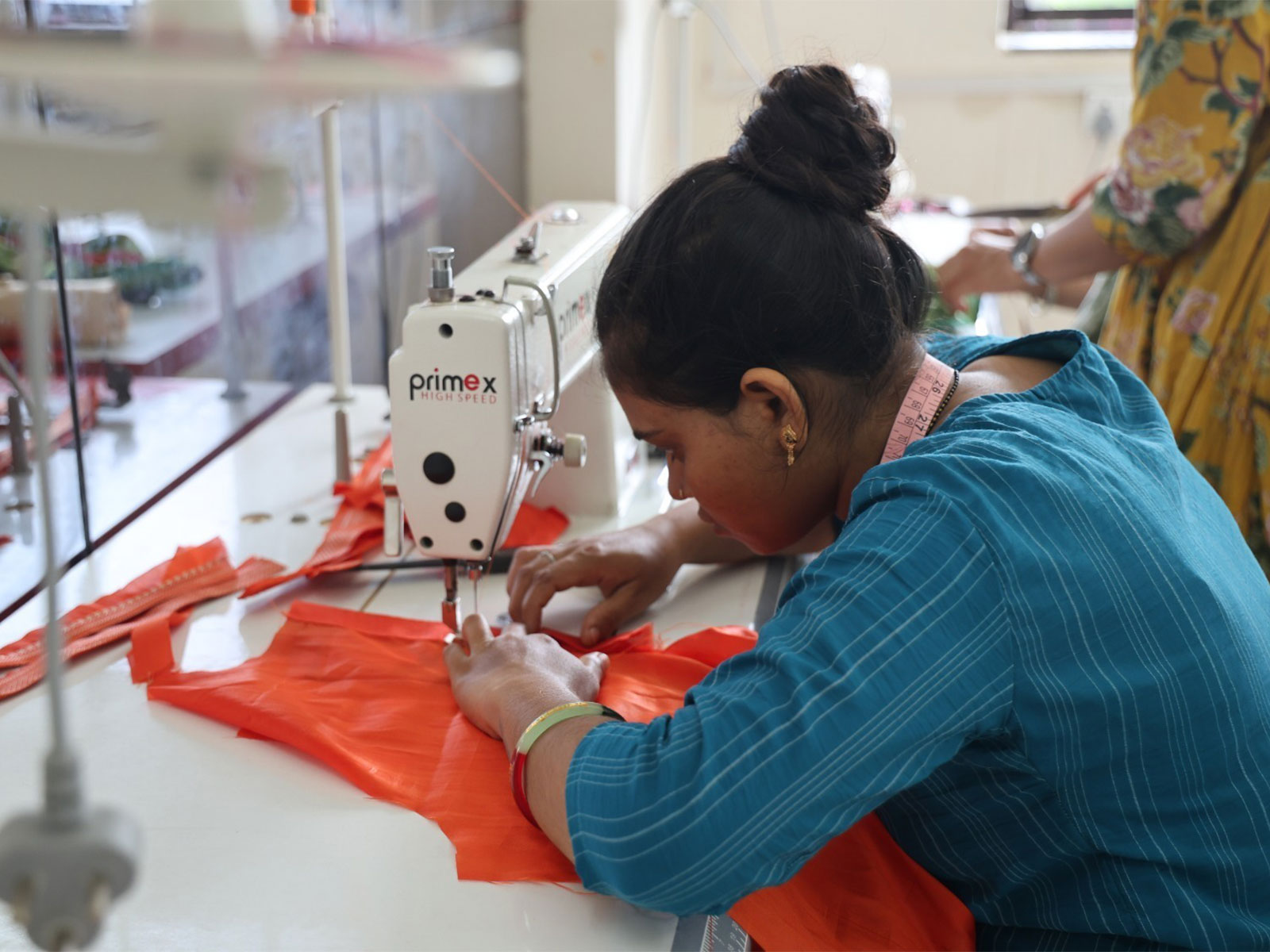 A woman stitching clothes for the Shree Somnath Trust’s Vastra Prasad initiative. (Photo/Gujarat CMO)