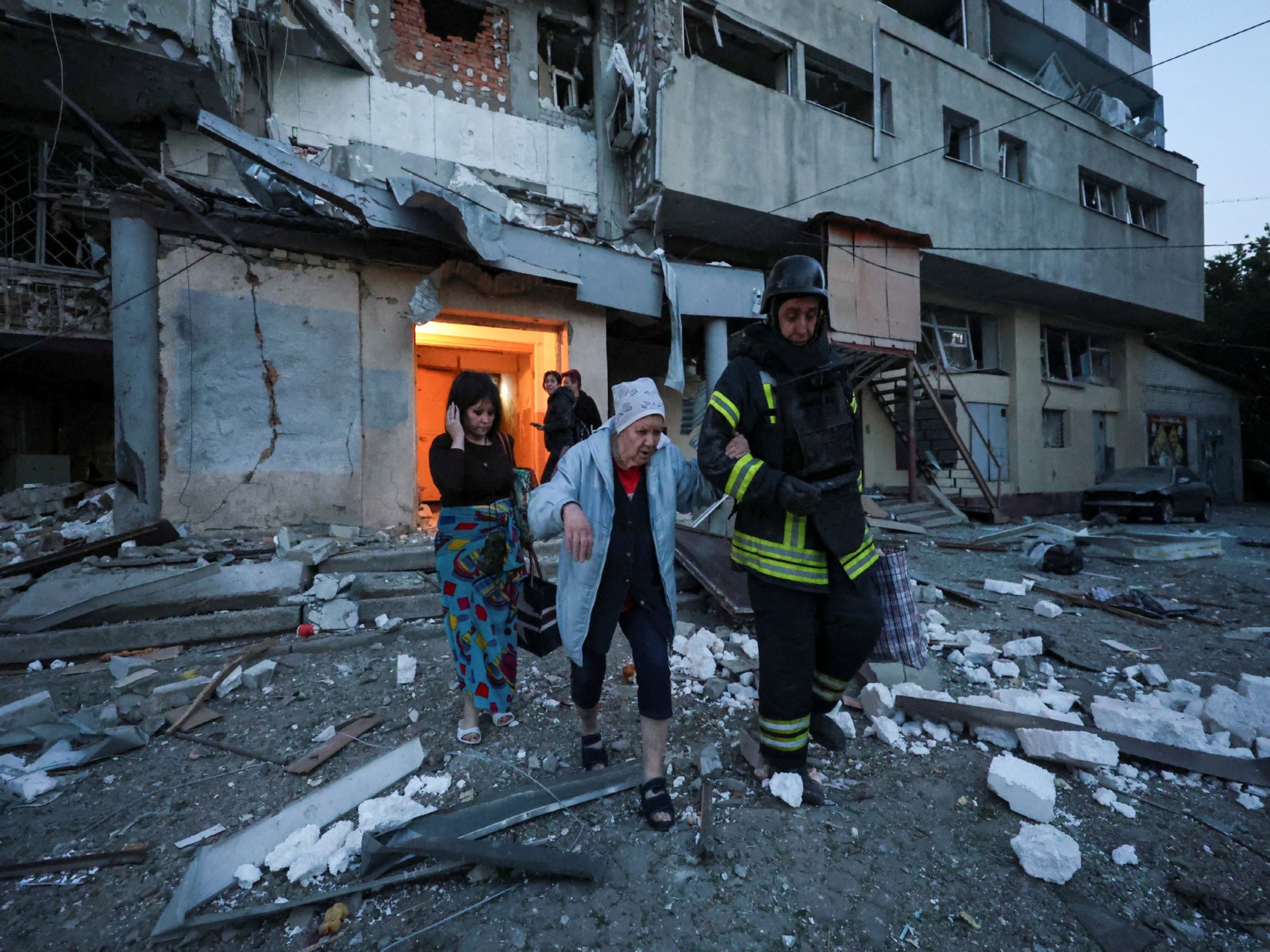 A rescuer helps a woman evacuate an apartment building damaged in a Russian drone strike in Kharkiv, Ukraine. (File Photo/Reuters) A rescuer helps a woman evacuate an apartment building damaged in a Russian drone strike in Kharkiv, Ukraine. (File Photo/Reuters)