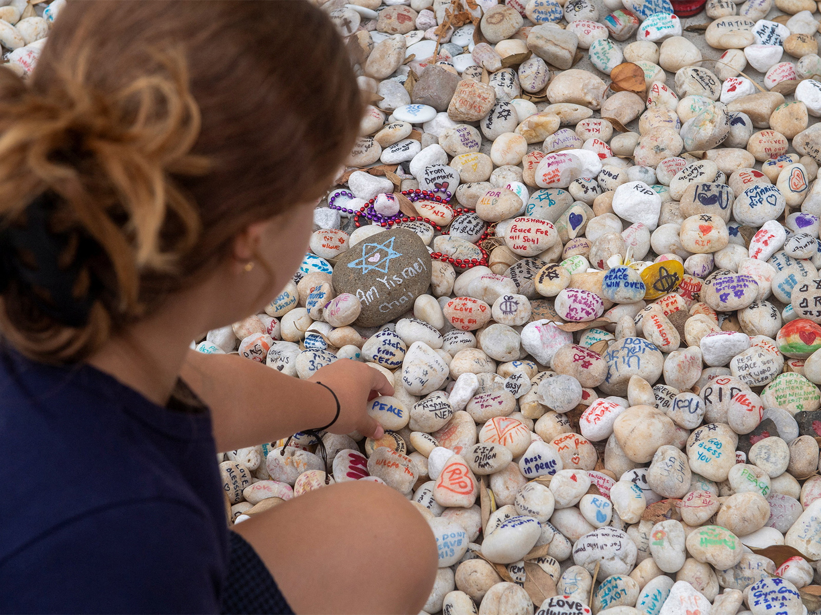 A visitor places a pebble at a memorial site in remembrance to the lives lost during the Bondi Beach mass shooting on December 14, 2025, in Sydney (Photo/Reuters)
