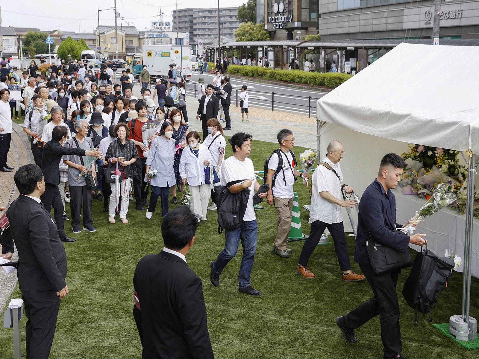 People queue up to offer flowers and pray at the site where late Japanese Prime Minister Shinzo Abe was shot (Photo/Reuters)