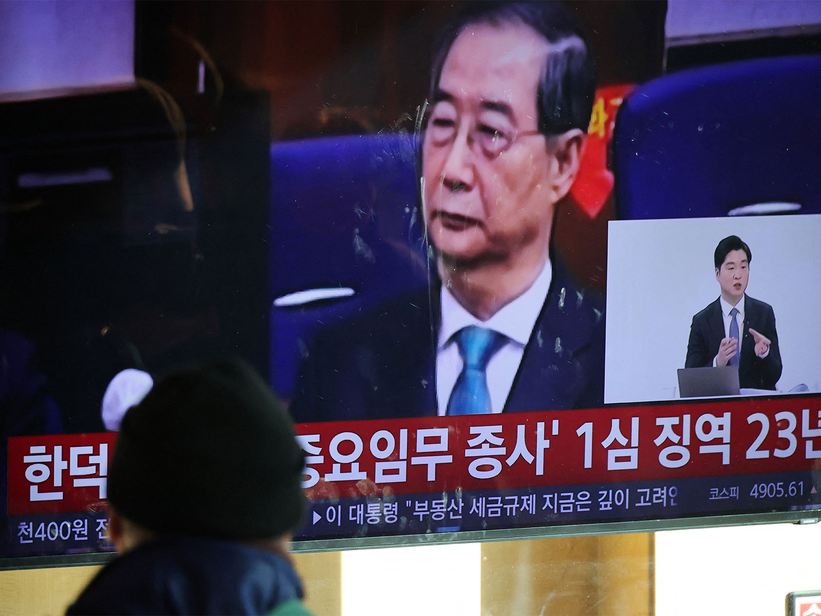 People watch news as S Korea’s former PM Han Duck–soo gets 23 years jail in martial law case (Photo/Reuters)