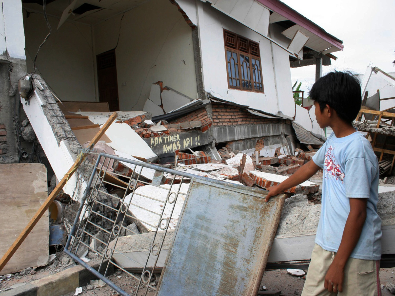 A boy looks at a damaged house rocked by earthquakes, in Solok, West Sumatra province March 6, 2007. (File Photo/Reuters)