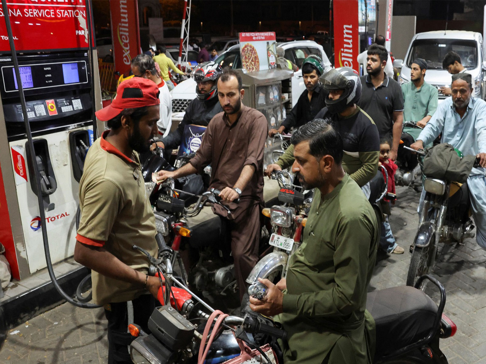 People wait for their turn to get fuel at a petrol station in Pakistan (Photo/ Reuters)