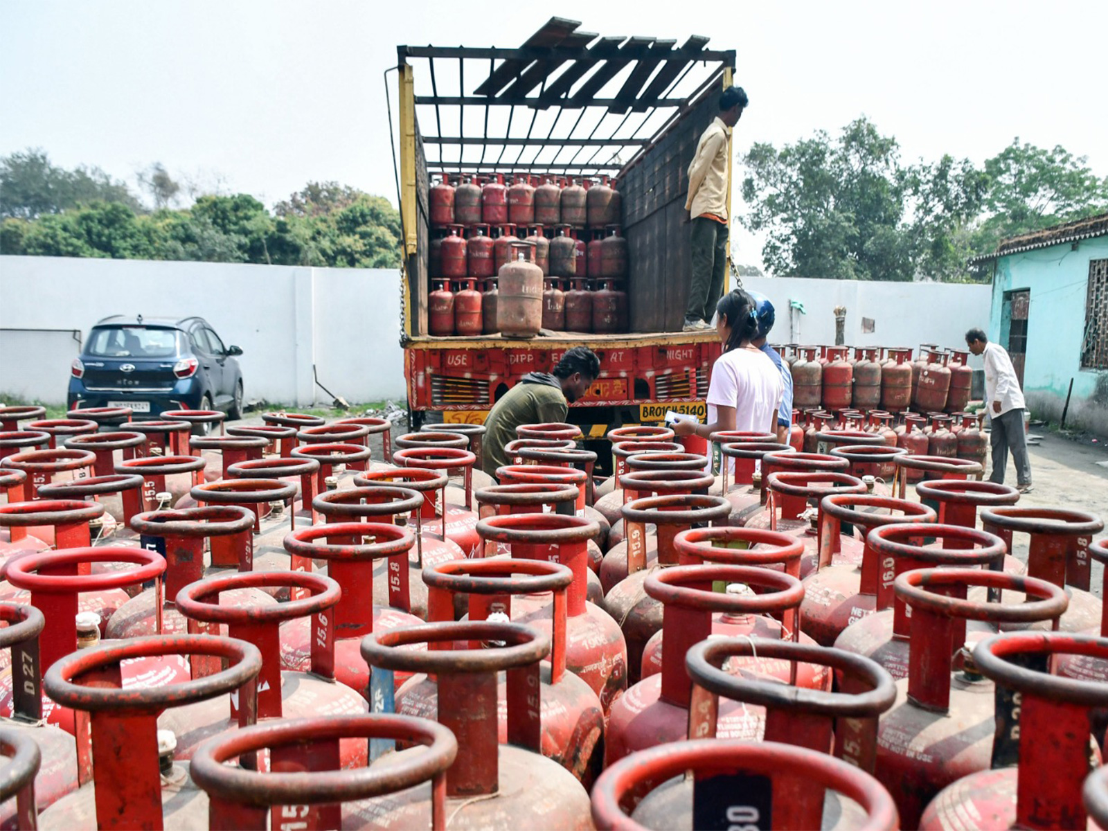 Delivery boy unloads an LPG cylinder from a truck (Photo/ANI)