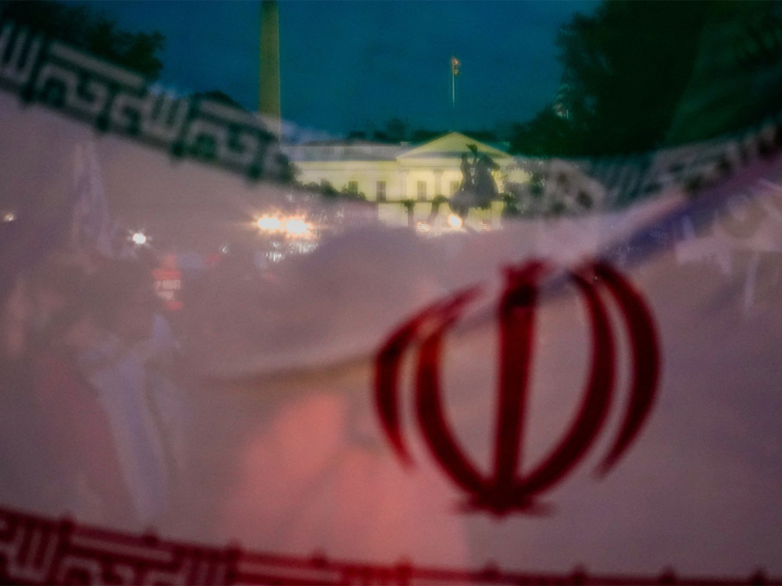 The White House is seen through Iran's flag during a protest against military action in Iran (Photo/Reuters)