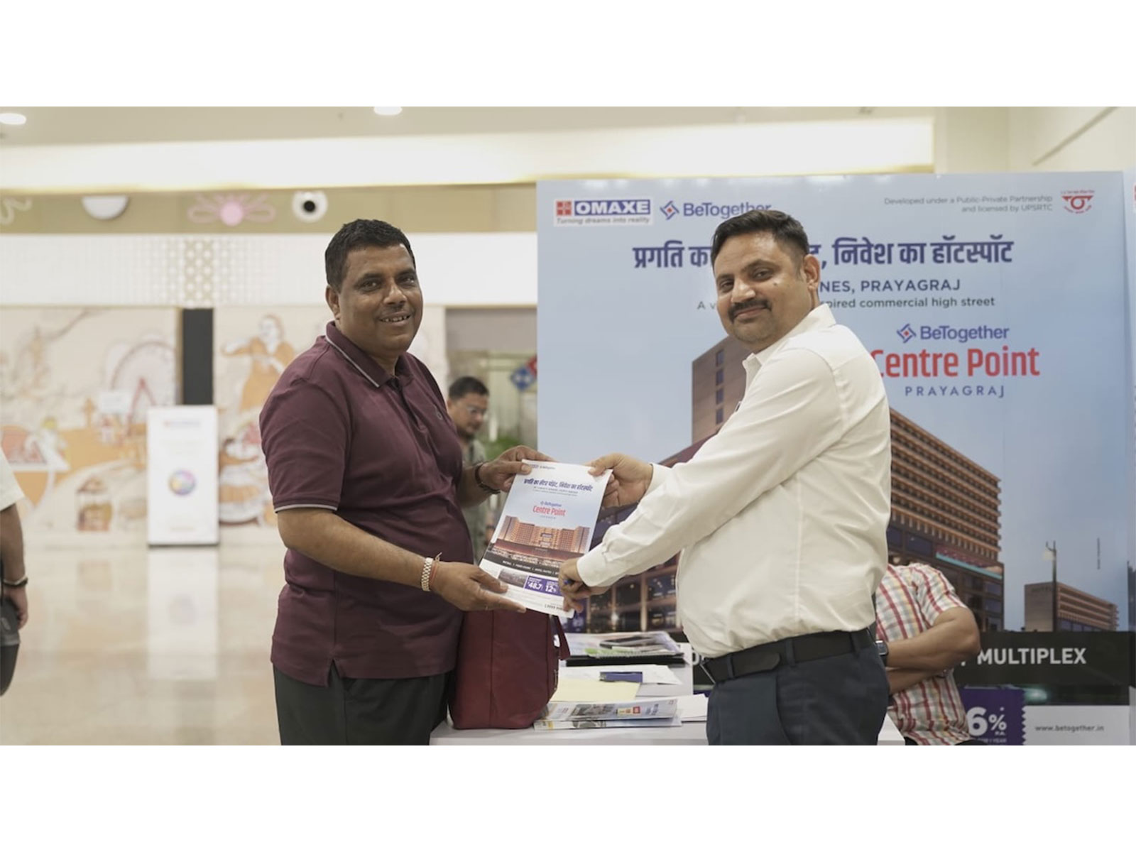 Omaxe BeTogether Centre Point Prayagraj brochure handover at real estate property exhibition stall Omaxe BeTogether Centre Point Prayagraj brochure handover at real estate property exhibition stall