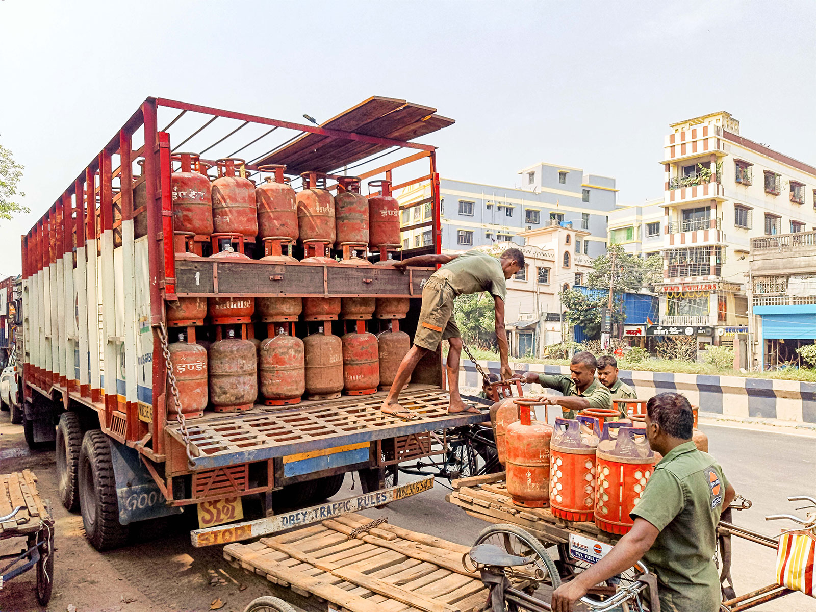 A worker unloads LPG cylinders from a truck at an Indian Oil Corporation LPG distributor facility at Belgharia, in Kolkata (Photo/ANI)