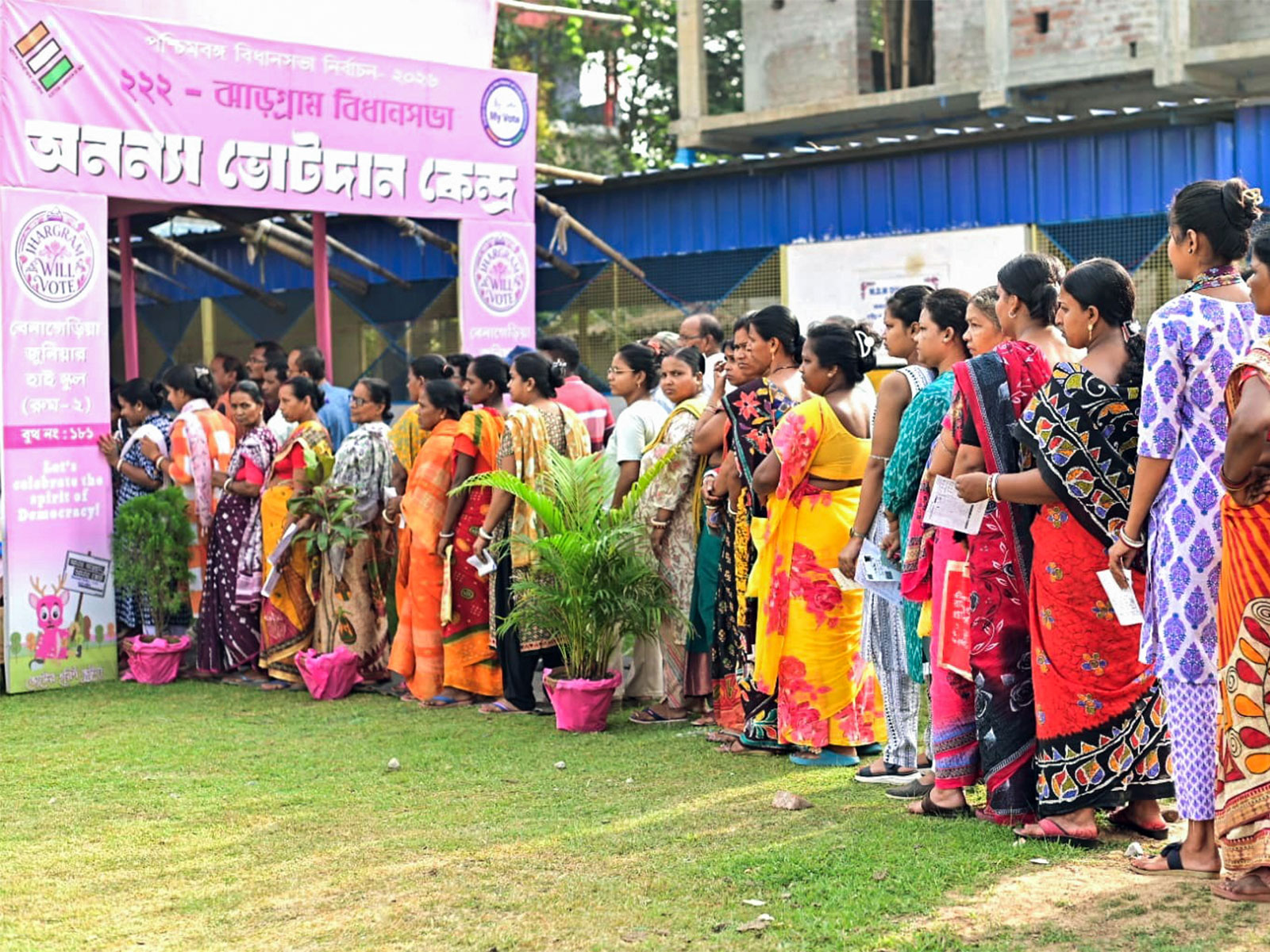 Voters stand in a queue at a polling booth in Bengal's Jhargram (File Photo/ANI)