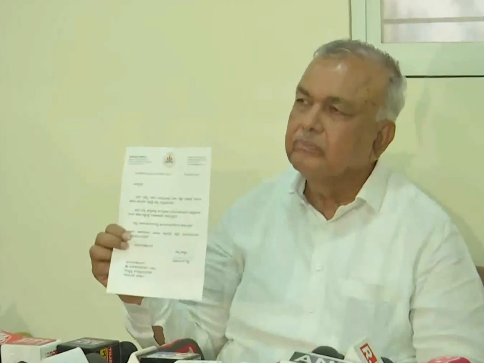 Karnataka Minister Ramalinga Reddy showing his resignation letter to the media (Photo/ANI)