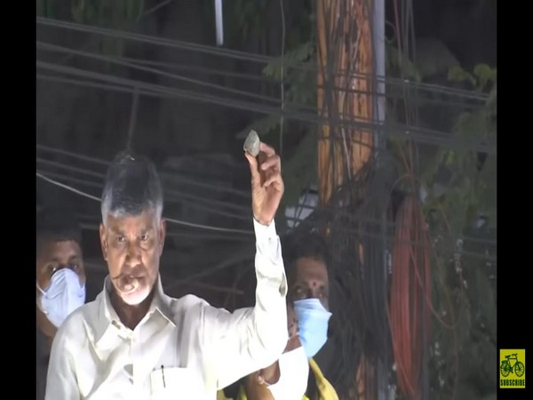 Former Andhra CM showing the stone which was pelted on his convoy. (Photo/ANI)