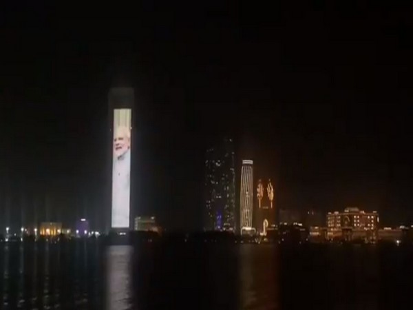 The facade of the ADNOC tower in Abu Dhabi lit up with flags of India and UAE and portraits of two leaders of both countries.