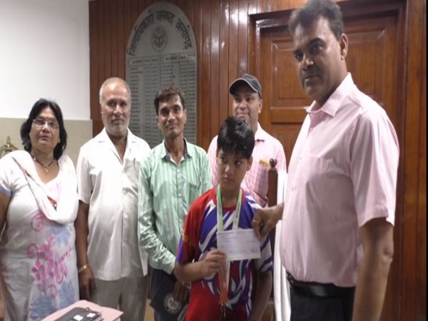 Aligarh District Magistrate Chandrabhushan Singh (right) giving cheque to Chandhary Singh Choudhary.