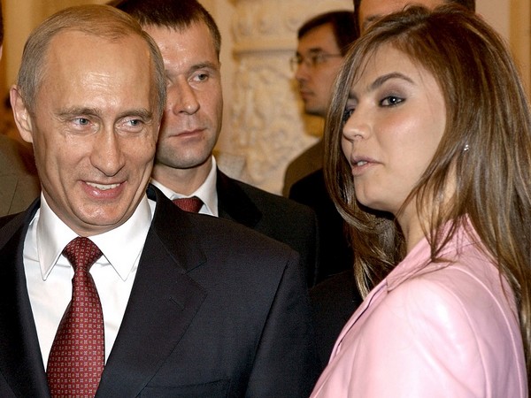 Russian President Vladimir Putin smiling next to Russian gymnast Alina Kabaeva. (Photo Credit - Reuters)