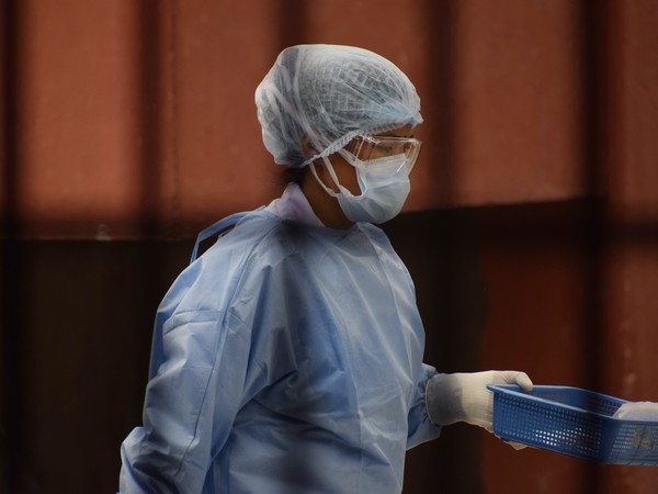 A healthcare worker carrying swabs for coronavrius testing in Nepal