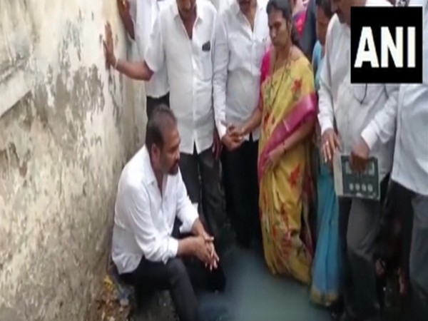 YSR Congress Party (YSRCP) leader Kotamreddy Sridhar Reddy sitting with his legs dipped in the drain (Photo/ANI)