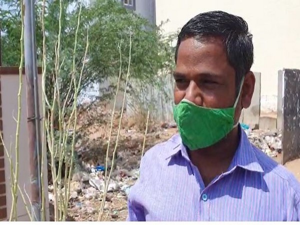 Ramesh, a local shopkeeper in Anantapuram, showing plants destroyed by locusts. Photo/ANI