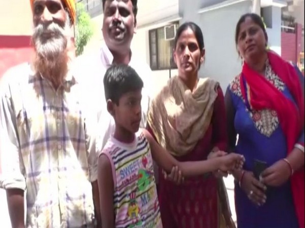 Family members showing the arm of student which was stamped for not paying fee