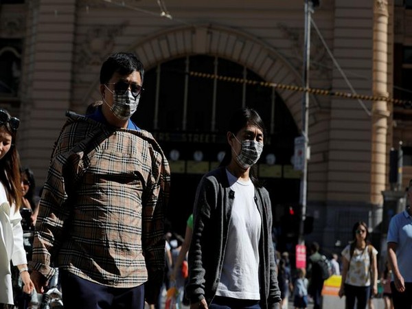 People wear masks in Melbourne, Australia, as the confirmed Covid-19 cases reach 100 in the country.