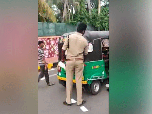 Motor vehicles inspectors and constables of the RTA pasting Jagan Reddy's sticker on Autos in Vijayawada on Tuesday. (Photo/ANI)