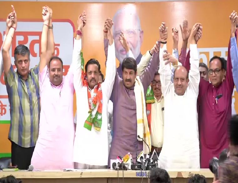 Delhi BJP Chief Manoj Tiwari and BJP leader Vijender Gupta with the new joinees on Saturday. Photo/ANI