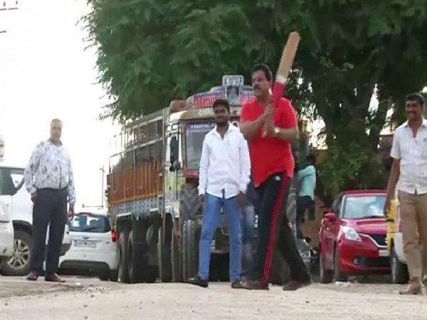 Bharatiya Janata Party MLA SR Vishwanath playing cricket with reporters and locals outside his hotel in Bengaluru. Photo/ANI