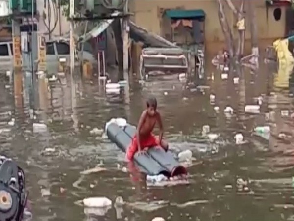 A boy rowing a boat in the stagnane water in Patna on Friday [Photo/ANI]