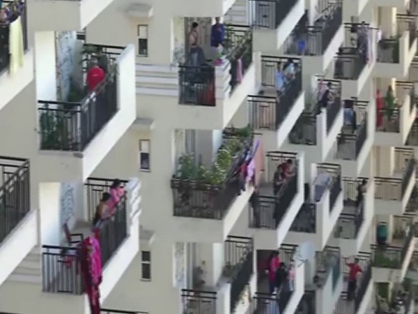 People in their balconies to express their gratitude to medical professionals engaged in fighting against COVID-19 . Photo/ANI