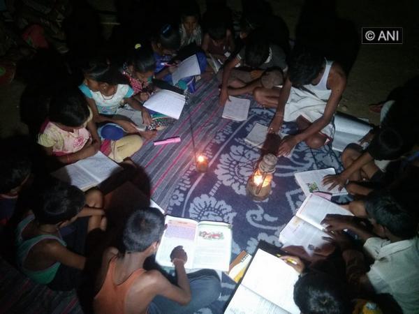 Children studying using a Kerosene lamp in Trishuli village of Balrampur. [Photo/ANI]