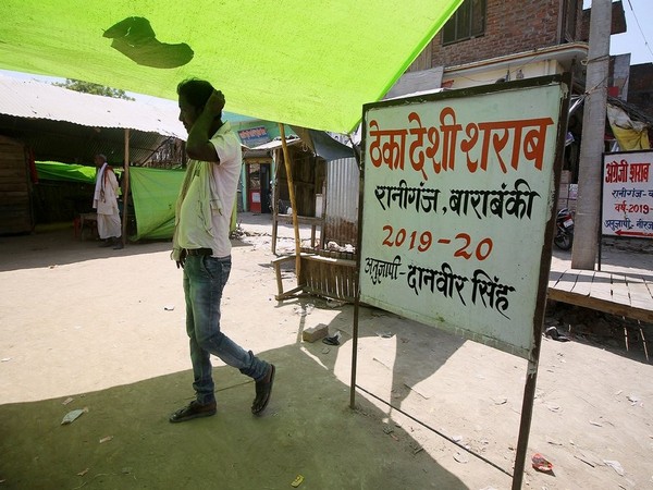 A man walks pass in front of the local liquor shop at Raniganj Village in Barabanki district on Tuesday. More than 12 persons died in the Hooch Tragedy. (ANI Photo)