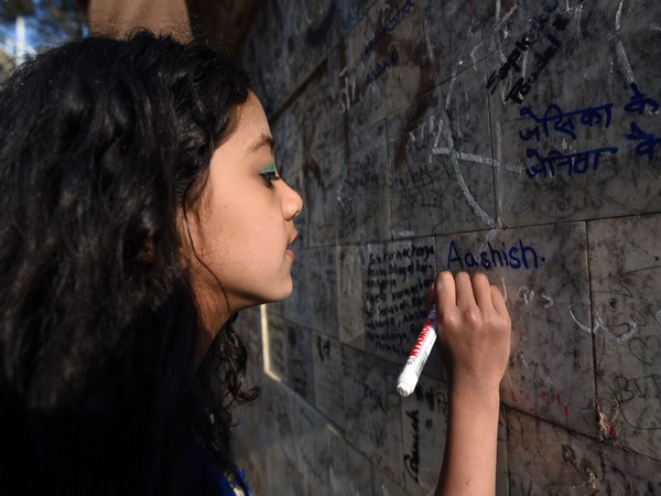 Students in Nepal celebrates the day of Basanta Panchami by writing their name on the temple wall 