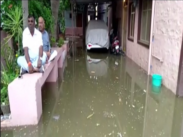 Bellari MLA Somashekhar Reddy staging a sit-in outside his residence agaist overflowing sewage water. Photo/ANI